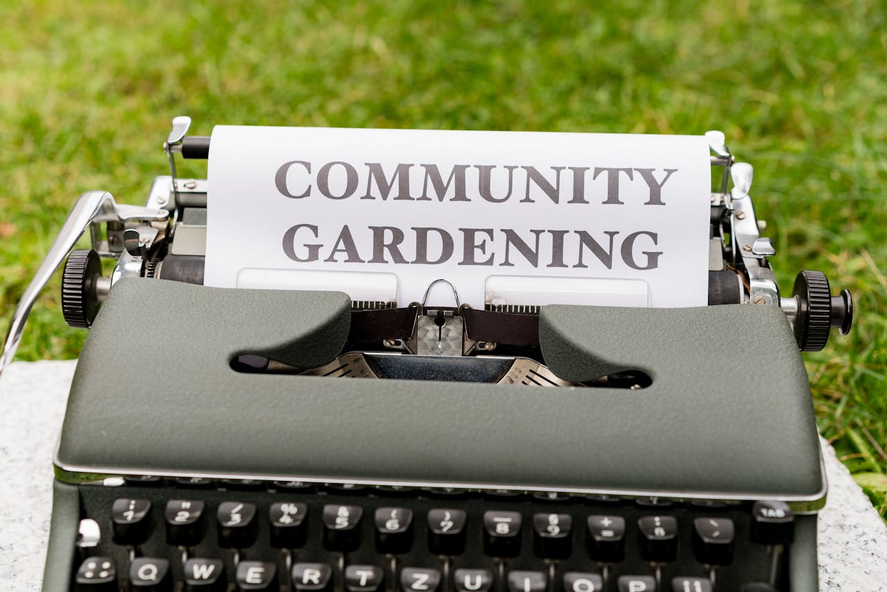 Vintage typewriter displaying community gardening message on paper outdoors.